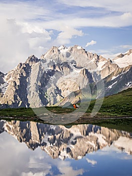 Mountains and tent reflecting in lake