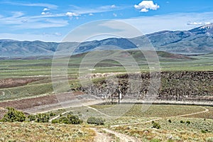 Mountains tower above the Oakley Dam and Lower Goose Creek Reservoir at Oakley, Idaho, USA