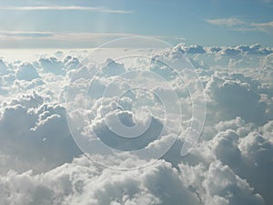 Flying over cotton-like clouds. Mountains of white clouds touching the sky photo