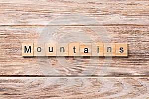 Mountains word written on wood block. mountains text on wooden table for your desing, concept
