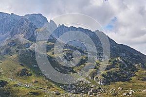 Mountainside with green ledges, and above it an impregnable rocky peak