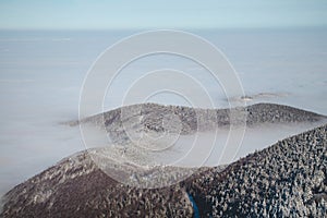 Mountainsides of the Beskydy region in the Czech Republic are sinking into a thick white inversion rising from the cities. Winter