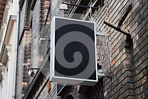 Mounted square sign on a wall with urban brick environment for advertising mockup. Template for logo, branding and corporate