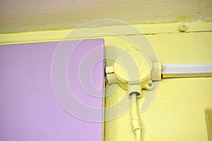 Mounting the electric cable on the wall in protection on a colored wall. Electrical wires are protected indoors