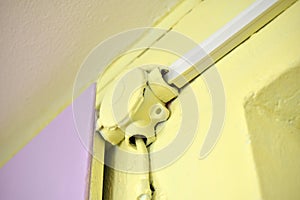 Mounting the electric cable on the wall in protection on a colored wall. Electrical wires are protected indoors