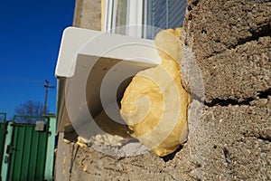 Mounting foam under the window sill.DIY concept. Construction PU - poly urethane foam. The window is installed using a photo