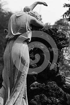 Mournful Woman Statue besides Huge Rock