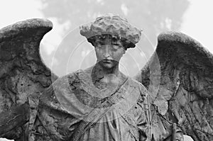 Mourning angel sitting on mausoleum on Cemetery Cimitero Monumentale Milan, Italy