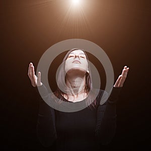 Mourning woman praying, with arms outstretched in worship to god