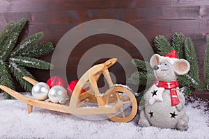 Mouse with Christmas preparations with balls and fir branch