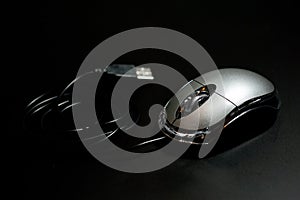 Mouse computer, wired, silver on a dark background