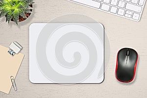 Mouse pad mockup. White mat on the table with props, mouse and keyboard photo