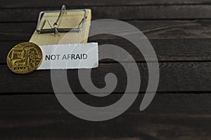 Mouse trap, backside of bitcoin and the word not afraid.