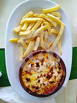 Moussaka in Greek way, served with french fries and more types of Greek cheeses