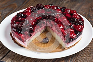 Mousse cake with berries on wooden background