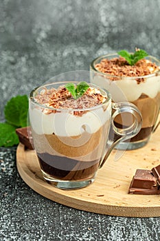 Mousse Three chocolates in a glass decorated with mint. Layered delicious dessert