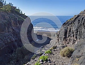 Mouth of Barranco de Guigui Grande gorge with view of empty sand beach Playa de Guigui in west part of the Gran Canaria