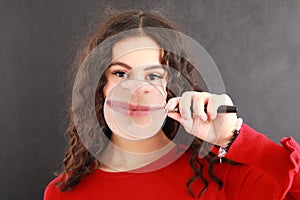 Mouth of pretty young teen girl in magnifying glass