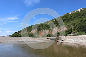 The mouth of the river Axe as it meets the sea at Axmouth in Devon. It is quite narrow and becomes a raging torrent when the tide