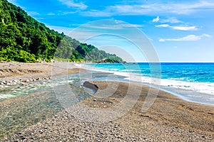 Mouth of the river to the sea on Playa Sana Rafael Beach, Barahona, Dominican Republic photo