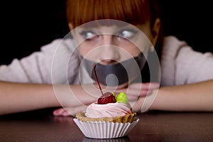 Mouth sealed with tape sad looking at cakes