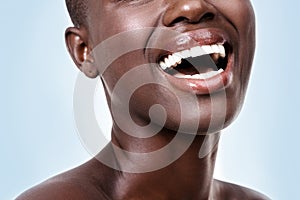 Mouth of woman, happy or laughing with beauty, cosmetics or healthy skin for shine isolated in studio. Face, closeup or