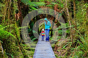 Mouther with little daughter walking in the rain forest. New Zealand