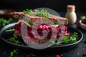 A mouthwatering sandwich topped with beets and fresh greens, served on a sleek black plate, Vegan sandwiches with beetroot hummus