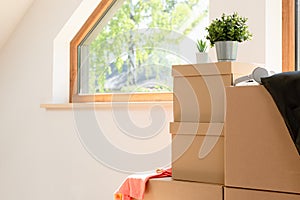 Move. Cardboard boxes for moving into a new, clean home. In a sunny day by a window in attic