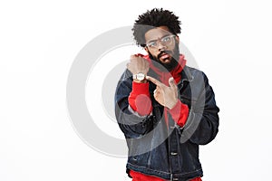 Move faster, clock ticking. Cool and stylish confident african american bearded male with afro hairstyle in denim jacket