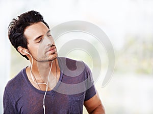 Moved by the music. a handsome man listening to music on his earphones.