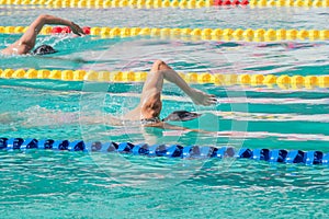 Movement of athletic swimmers swimming freestyle stroke front crawl or forward crawl during competition