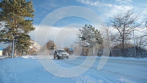 Movement of the cars in the winter. A driving on snow road, to a clear sunny day