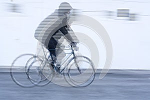 Movement of a cyclist with black jacket on white background