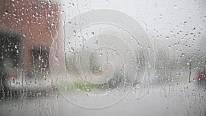 Movement of Rain falling on car windshield,drive car on street in city at heavy rain storm,blurred traffic light.