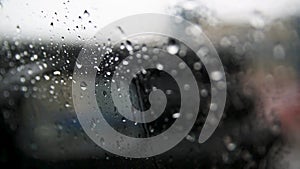 Movement of Rain falling on car windshield,drive car on street in city at heavy rain storm,blurred traffic light.