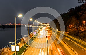 The movement of vehicles on the highway on the waterfront in the evening