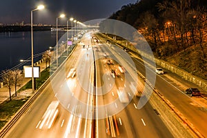 The movement of vehicles on the highway on the waterfront in the evening