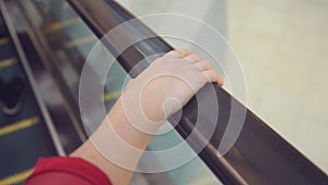 Movement of the woman`s hand on the escalator handrails. 4k, slow-motion, close-up.