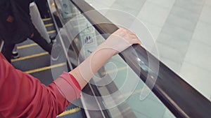 Movement of the woman`s hand on the escalator handrails. 4k, slow-motion, close-up.