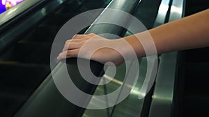 Movement of the woman`s hand on the escalator handrails. 4k, slow-motion, close-up