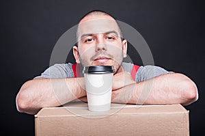 Mover guy having a coffee break on cardboard box
