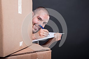 Mover guy hiding behind boxes taking notes