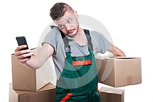 Mover guy holding cardboard box and browsing smartphone
