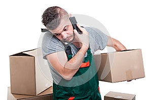 Mover guy holding cardboard box talking at phone
