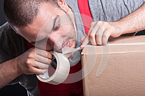 Mover guy ripping duct tape with teeth