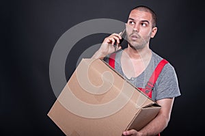 Mover man holding box talking on mobile phone