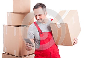 Mover man holding box and texting on smartphone