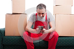 Mover man sitting on couch holding smartphone