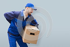 Mover Suffering From Backache While Carrying Parcel